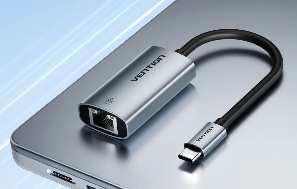 USB-C till Gigabit Ethernet-adapter placerad på bärbar dator, aluminiumhöljen