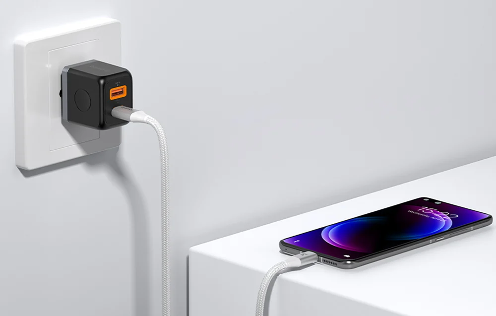 Flätad vit USB-C till C-kabel med aluminiumkontakter, ansluten till laddare och mobiltelefon