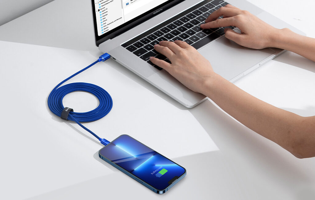 Blå USB-C till Lightning-kabel i tygmaterial med blå metallkontakter, laddar iPhone från MacBook