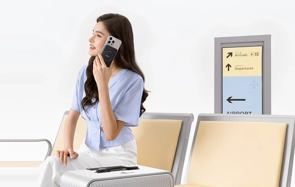 Kvinna på flygplats med Baseus PicoGo fäst på sin iPhone