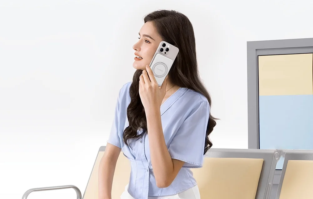 Kvinna på flygplats med vit Baseus PicoGo på sin iPhone